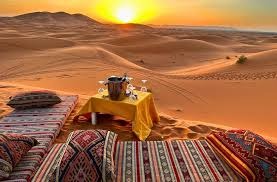 Relaxing setup with pillows on dunes at sunset